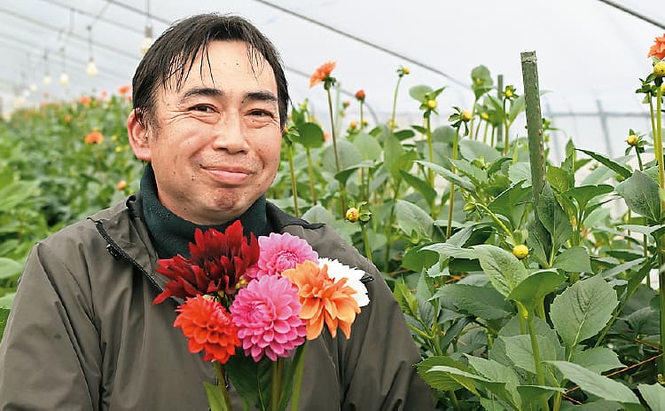 ダリアの花束を持ち笑顔の横尾弘友（よこお ひろとも）さんの写真